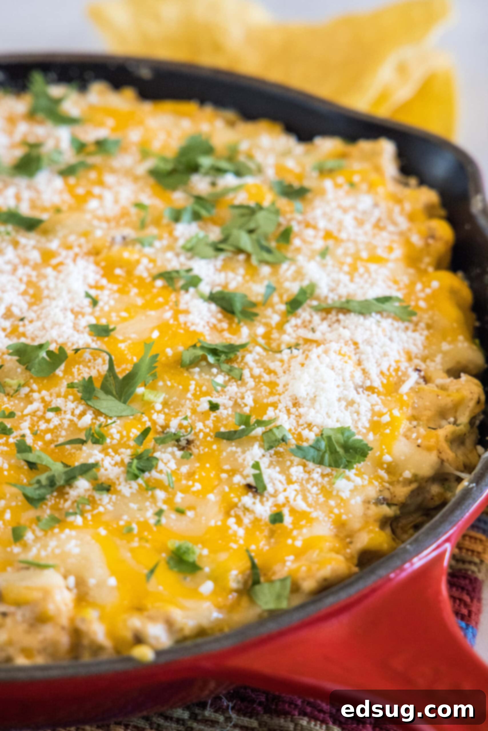 Baked street corn dip in a red skillet.