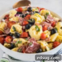 A perfectly portioned tortellini pasta salad in a white bowl, ready to be enjoyed.