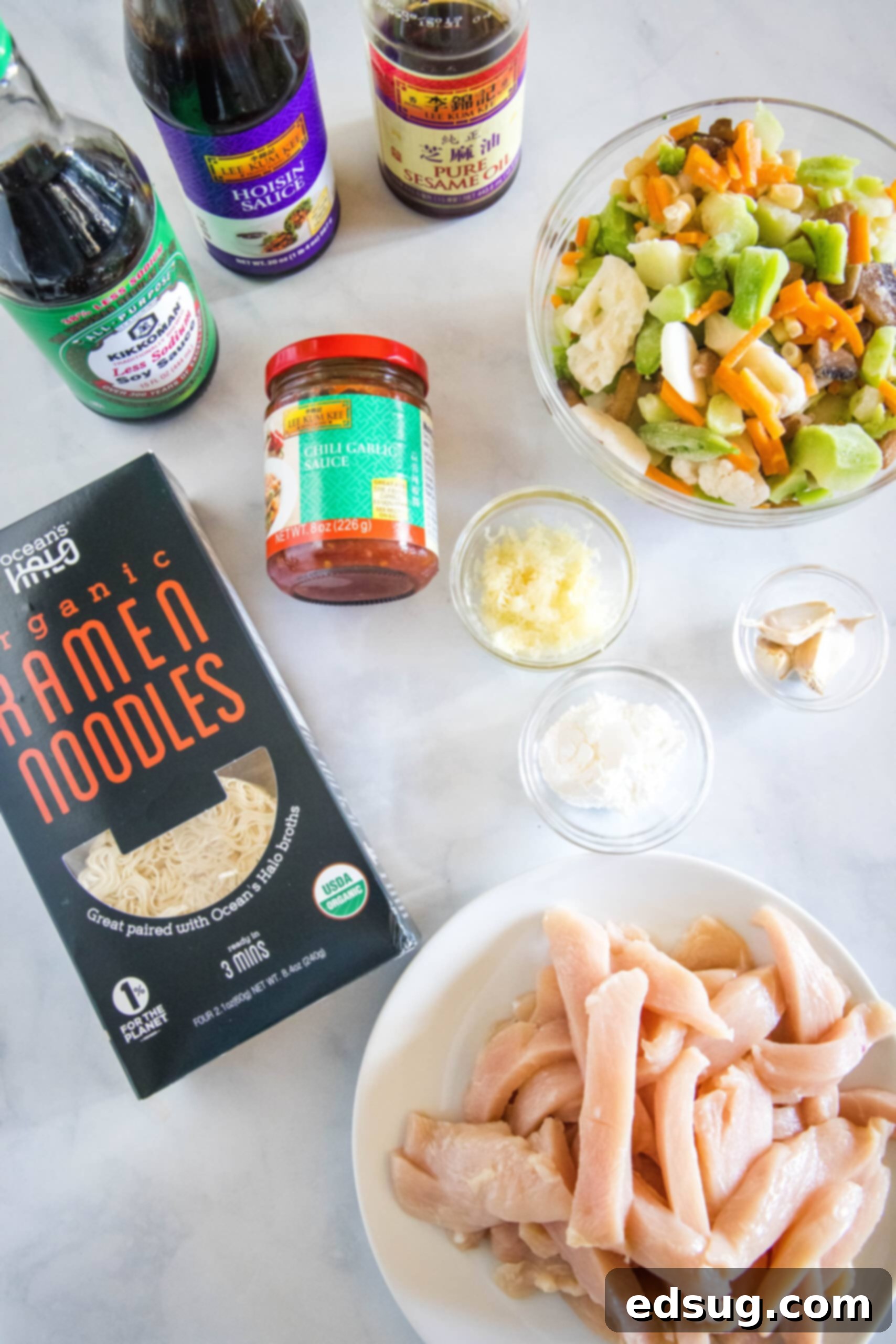 This 20-minute ramen stir fry is an easy meal packed with juicy chicken, veggies, and silky ramen noodles in a flavor-loaded stir fry sauce. Ingredients for chicken ramen stir fry laid out on a cutting board.