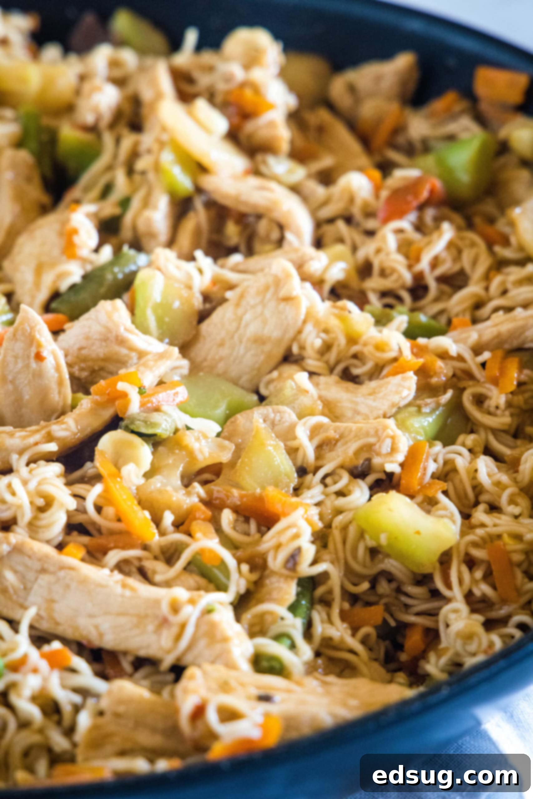 Close up of ramen stir fry with chicken and veggies in a skillet. Close up of ramen stir fry with chicken and veggies in a skillet, showing the glossy sauce.