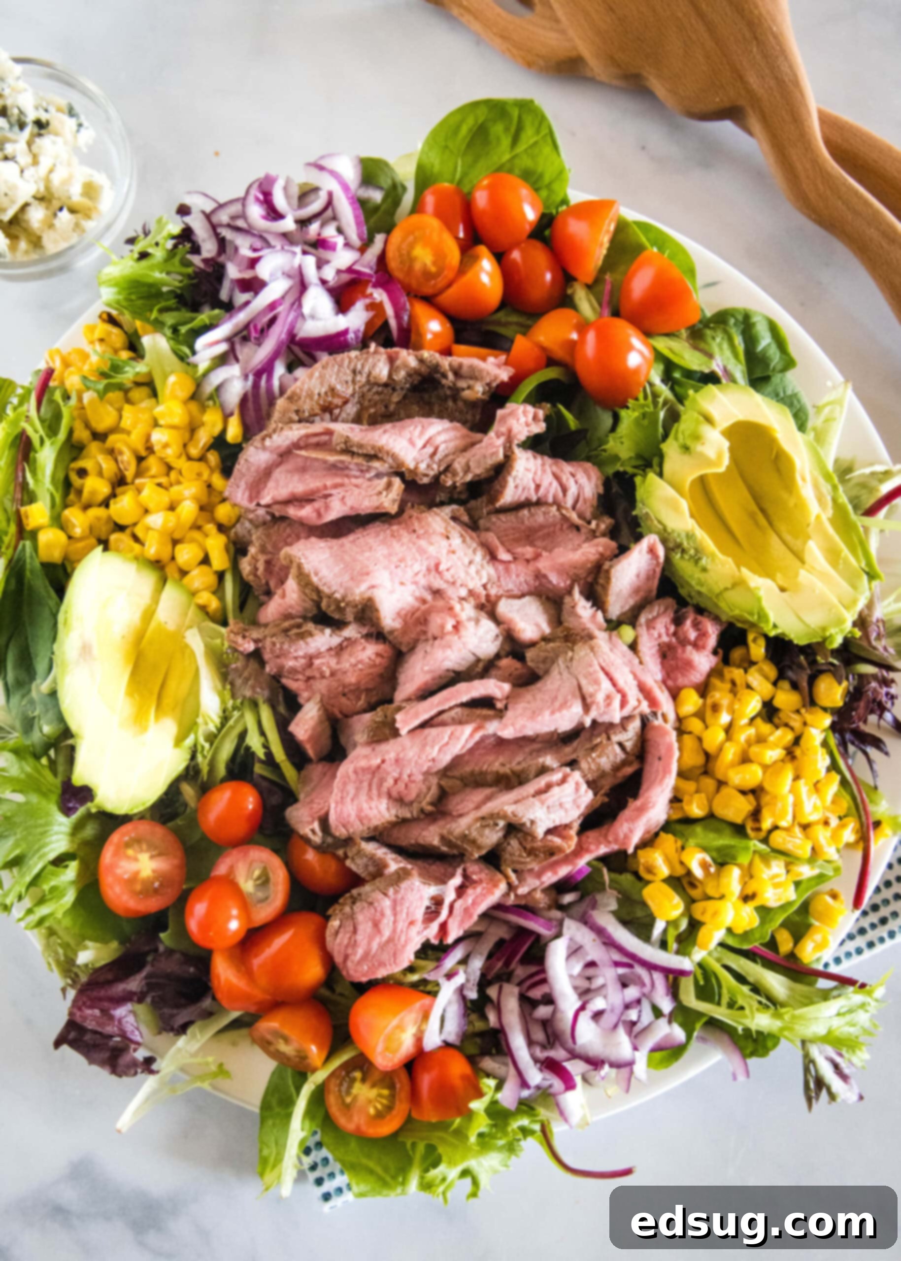 Overhead view of a steak salad on a large platter.