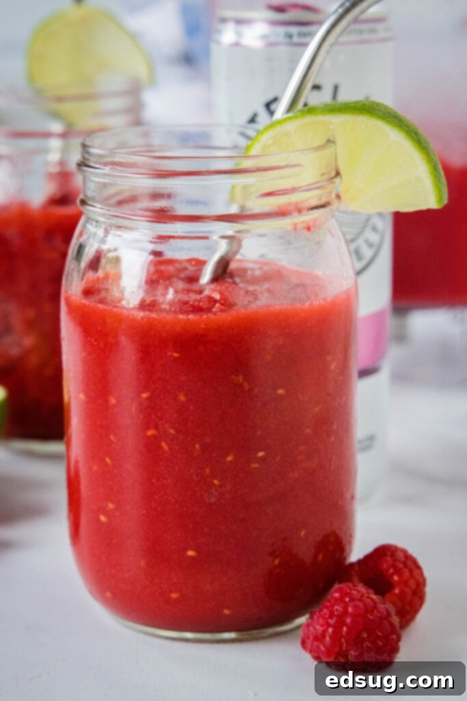 White Claw Chillers 2 white claw slushie in a glass with a straw and slice of lime