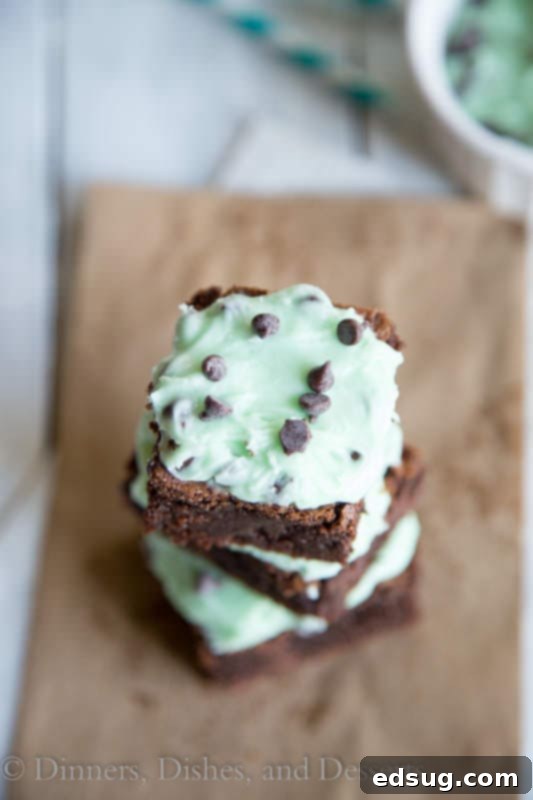 A tray of freshly frosted mint chocolate chip brownies, cut into squares, ready to be served