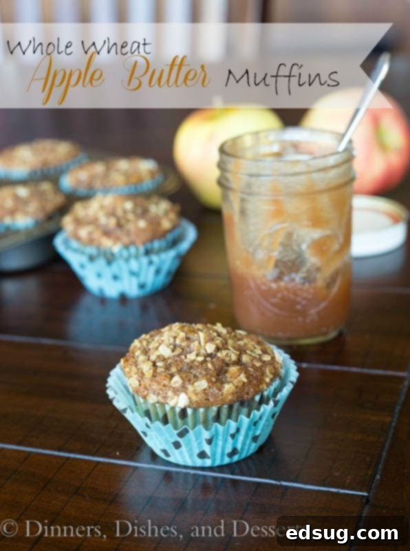 Warm whole wheat apple butter muffins cooling on a wire rack with autumn leaves in the background.