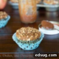 Close-up of a single Whole Wheat Apple Butter Muffin, perfectly baked with a crumb topping.