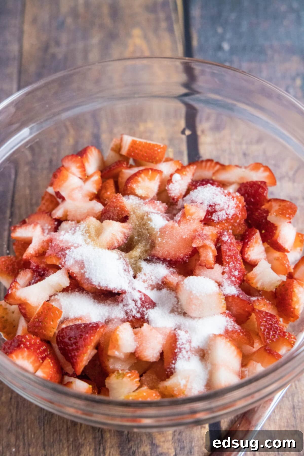 These 5-ingredient strawberry milkshakes are full of nostalgia and flavor. They're quick and easy to make, and absolutely delicious. A mixing bowl with sliced strawberries, sugar, and vanilla