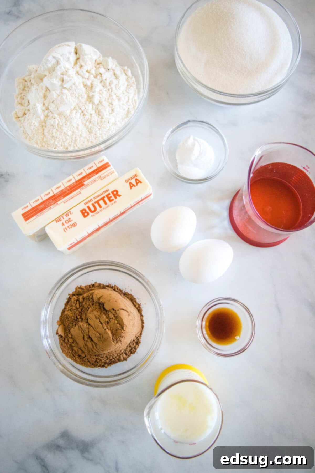 Irresistible Texas Sheet Cake 3 Collection of fresh ingredients for baking a Texas Sheet Cake, including flour, sugar, cocoa, butter, eggs, and milk.