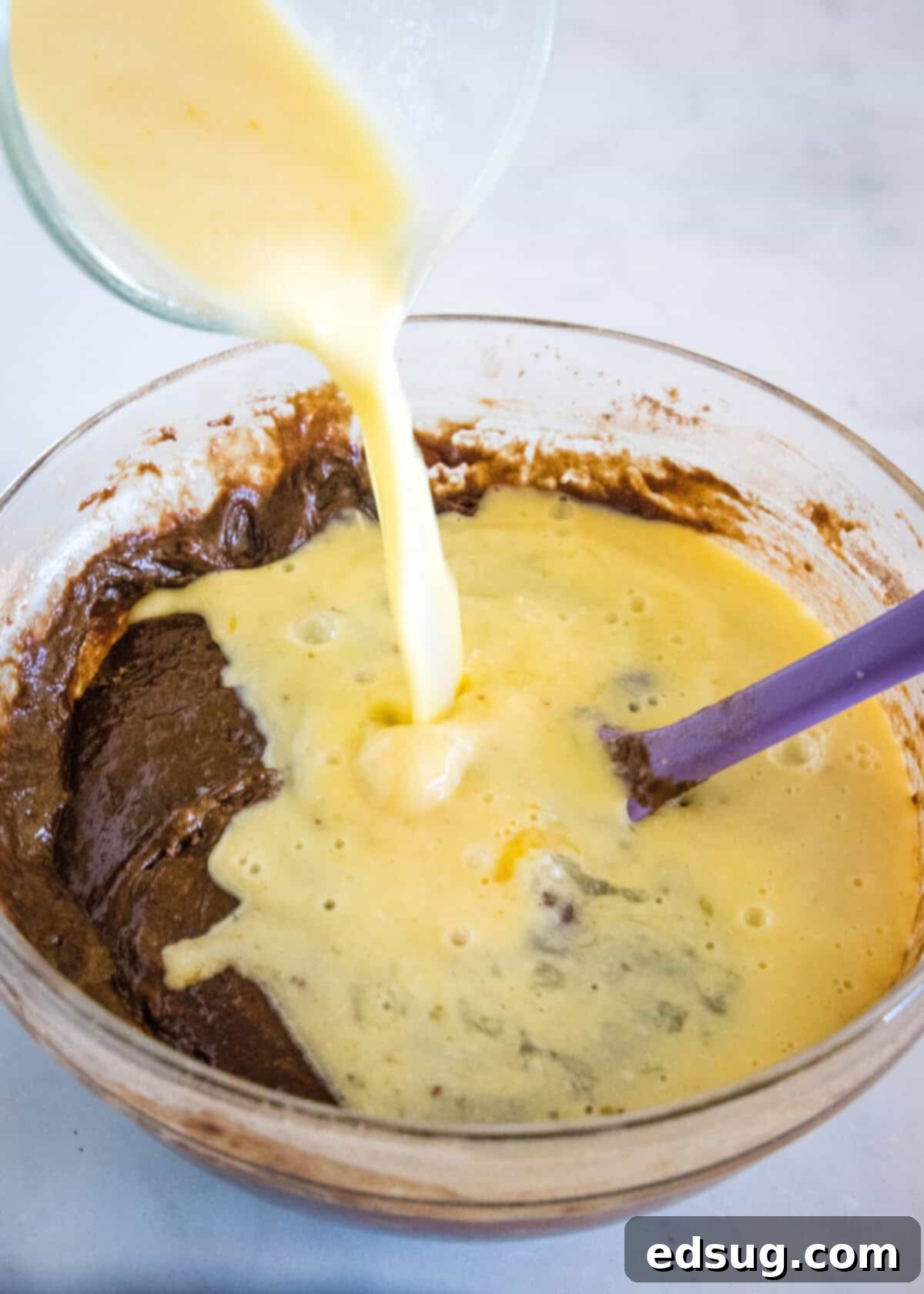 Irresistible Texas Sheet Cake 6 Egg, vanilla, and sour milk mixture being added to the chocolate cake batter for Texas Sheet Cake.