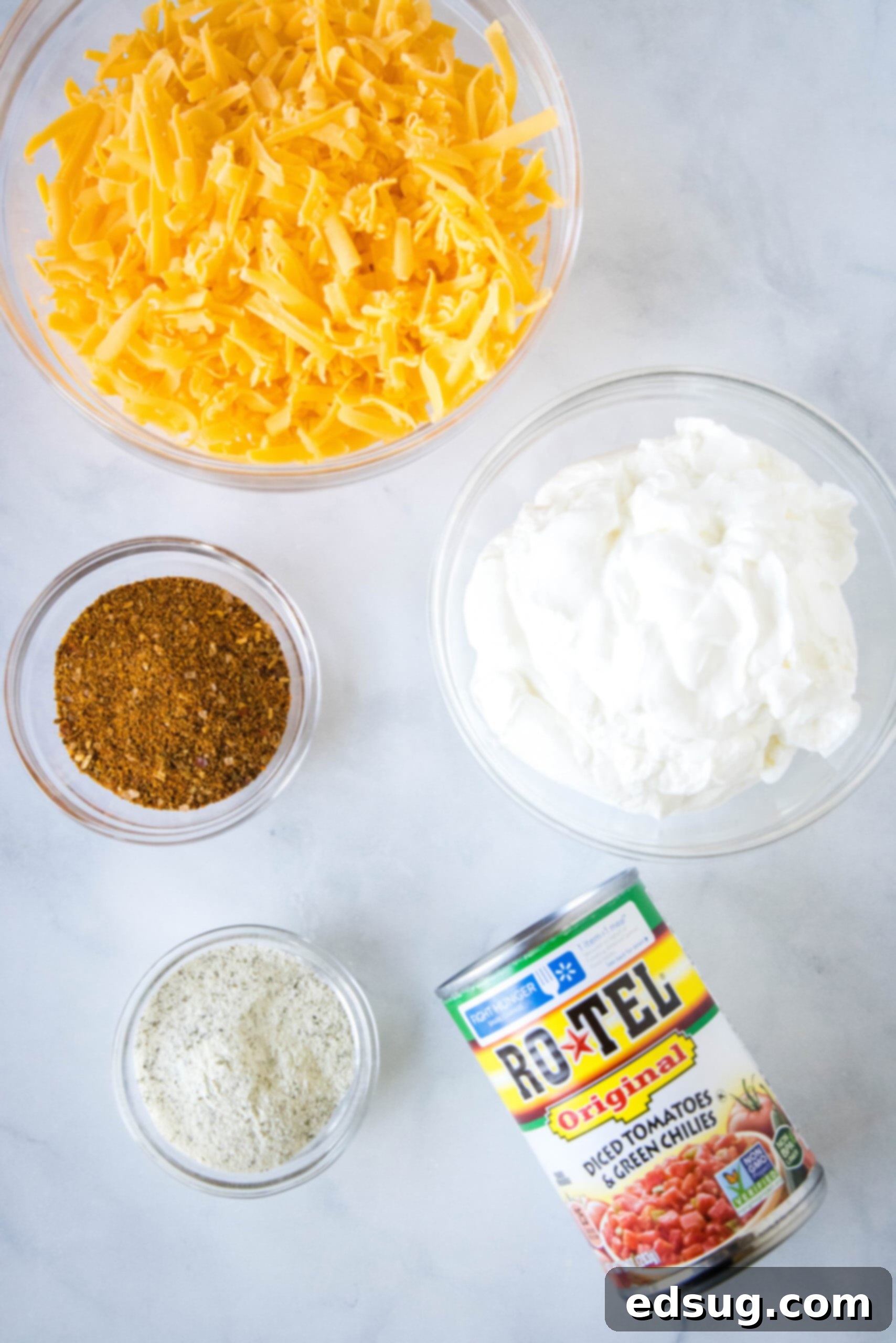 Boat dip is a cool, creamy taco dip inspired by the viral TikTok recipe! It's the perfect easy appetizer for your next summer BBQ or potluck. All five core ingredients for the viral TikTok boat dip laid out on a white surface.