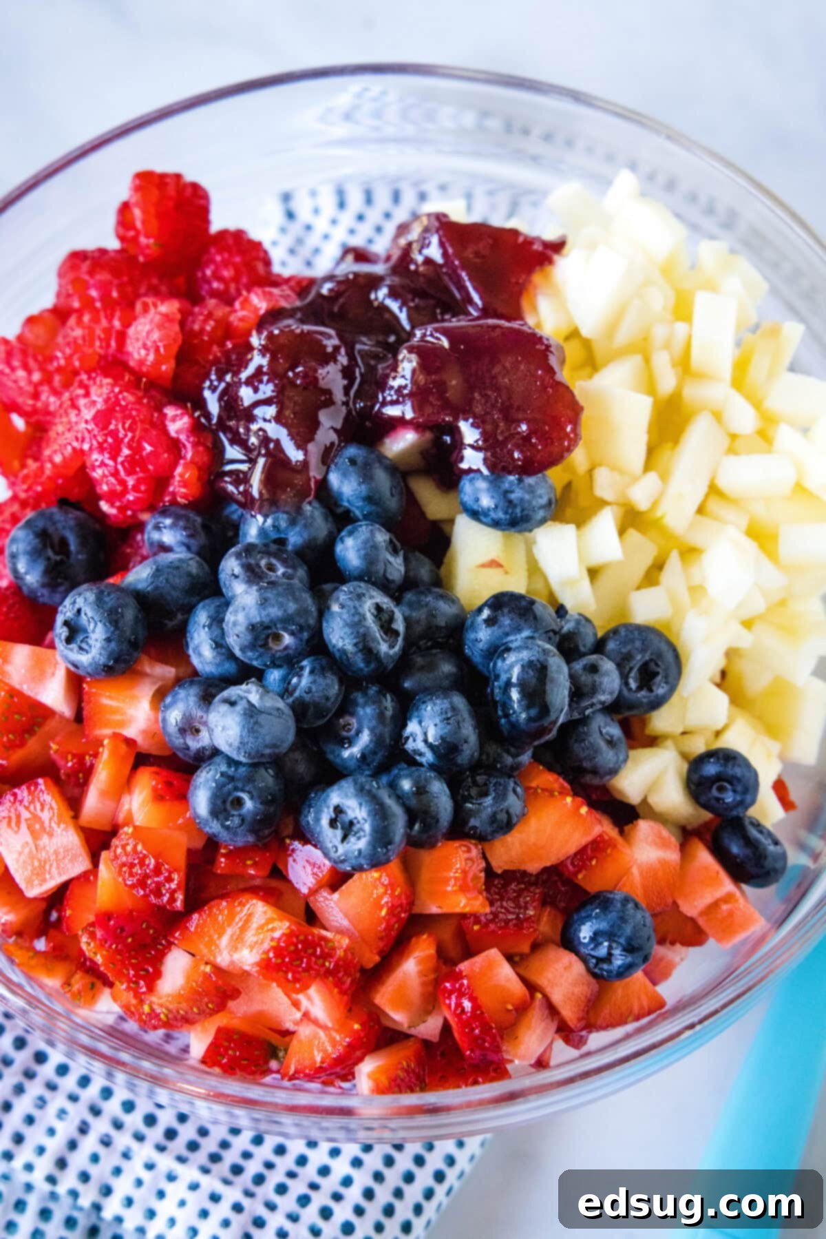 This fruit salsa is a sweet summer salsa recipe bursting with fresh seasonal berries. Serve it with cinnamon chips for a light and easy snack! Fruit salsa ingredients combined in a glass bowl.