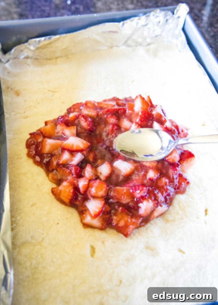 spreading strawberry filling onto the baked shortbread crust