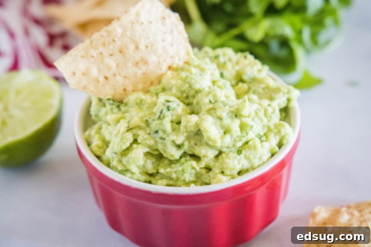 Smoky Garlic Guac Perfection 5 A close-up shot of a rustic ceramic bowl filled with freshly prepared roasted garlic guacamole, garnished with a sprinkle of chopped cilantro and a vibrant lime wedge, ready to be served as an appetizer.