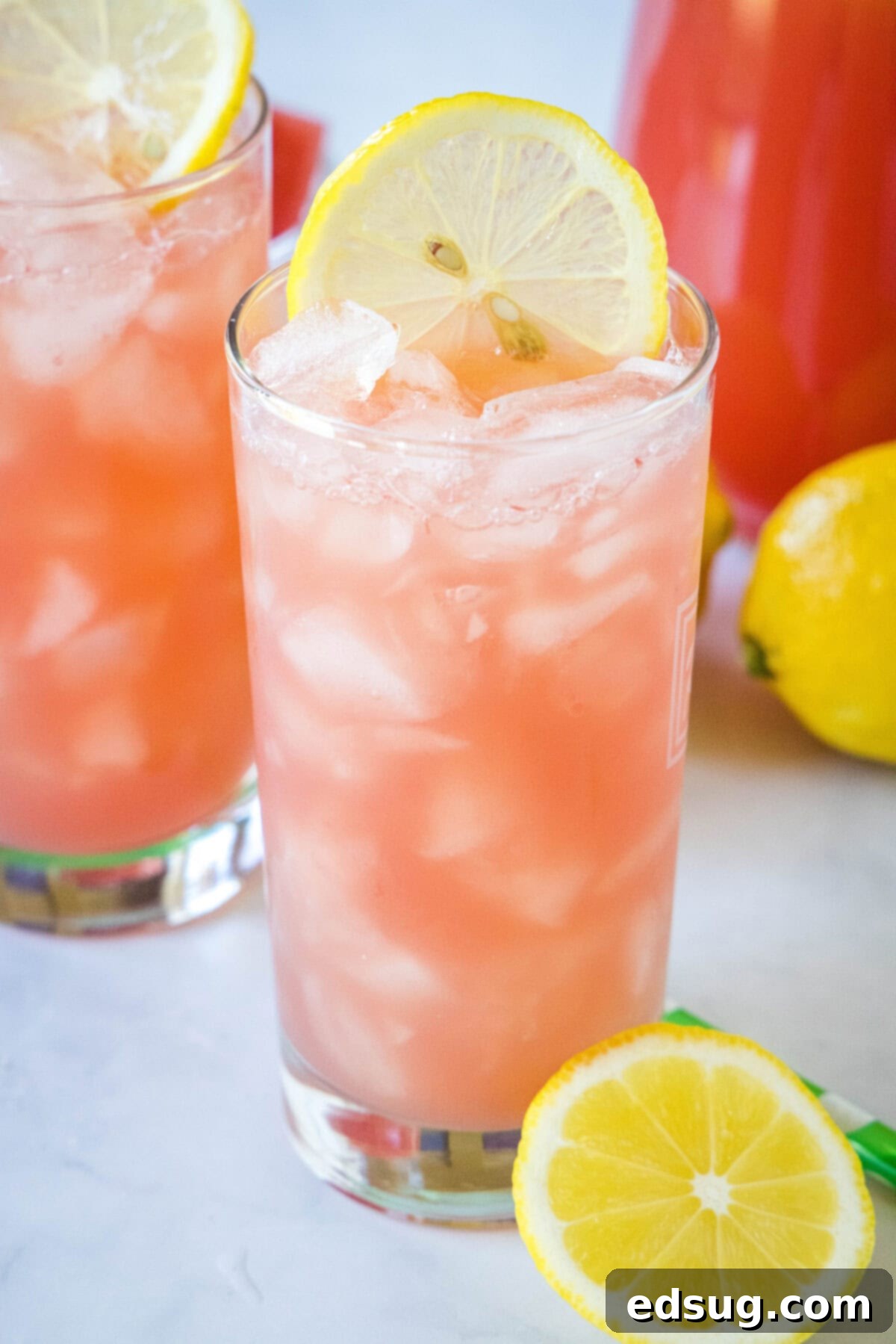 Sunny Watermelon Lemonade 2 Vibrant watermelon lemonade in a tall glass, garnished with fresh mint and a lemon slice.