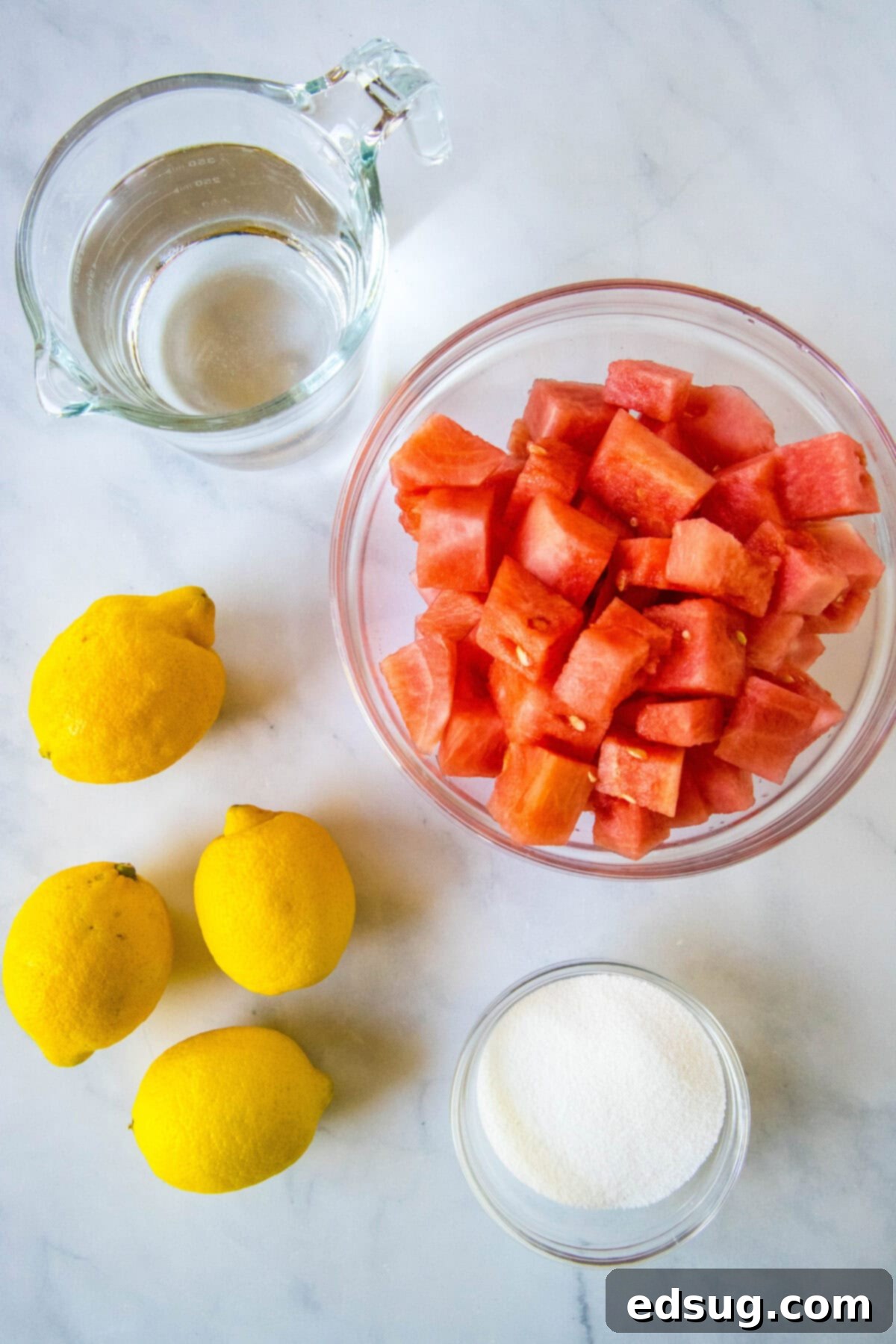 Sunny Watermelon Lemonade 3 Fresh ingredients for watermelon lemonade: cubed watermelon, whole lemons, and a glass of strained watermelon juice.