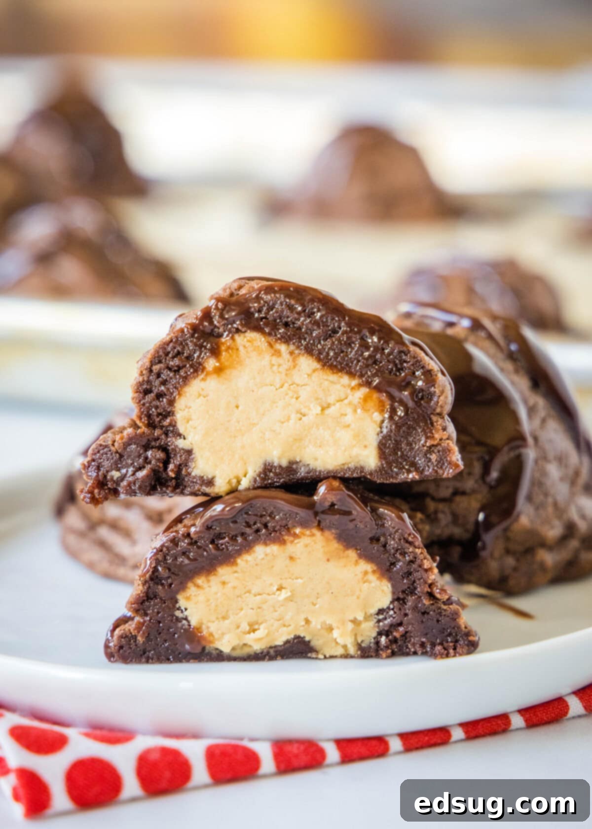 Decadent Chocolate Peanut Butter Truffle Cookies 2 peanut butter stuffed cookies on a plate cut in half showing the creamy center