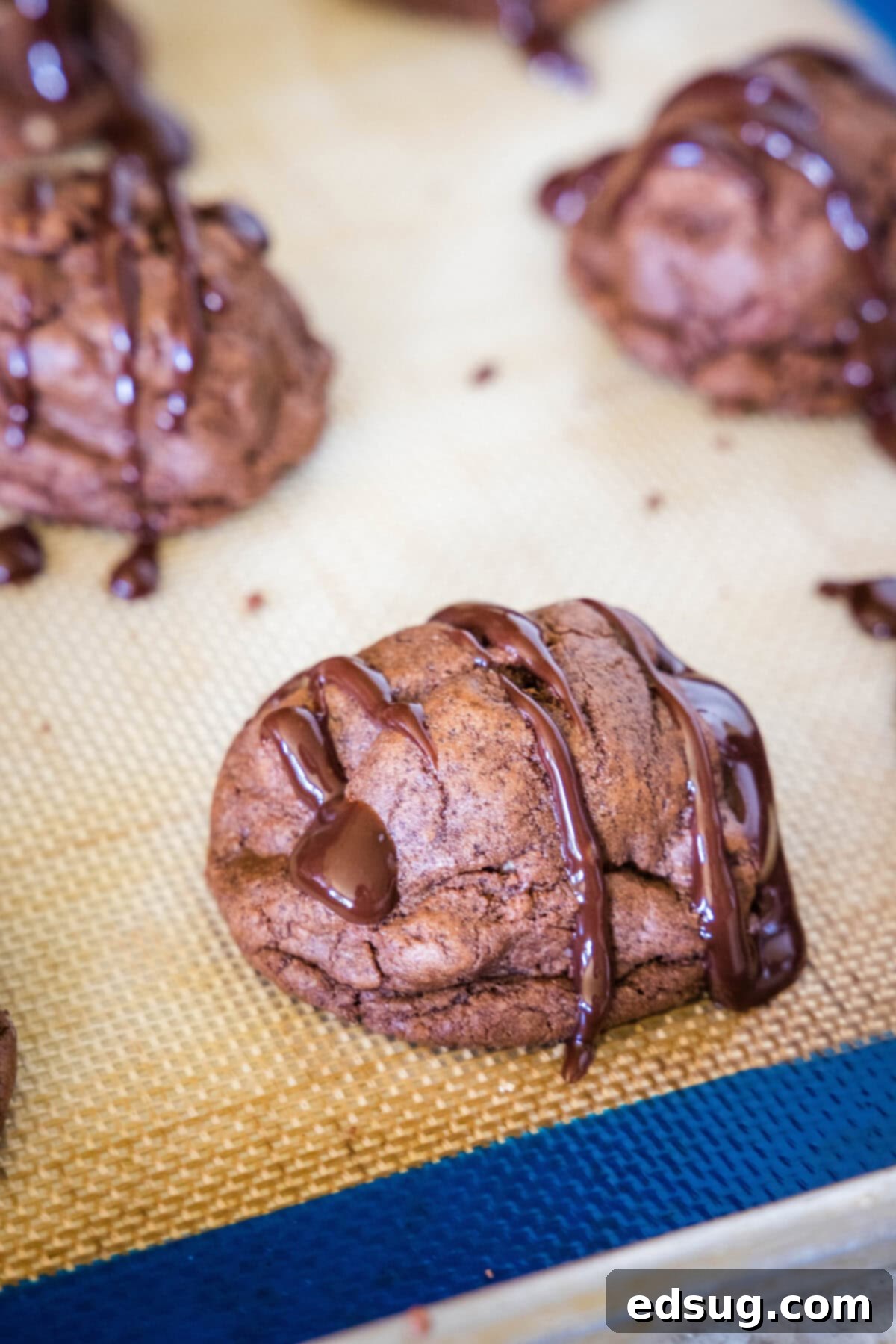 Decadent Chocolate Peanut Butter Truffle Cookies 6 peanut butter stuffed cookies on a baking sheet cooling