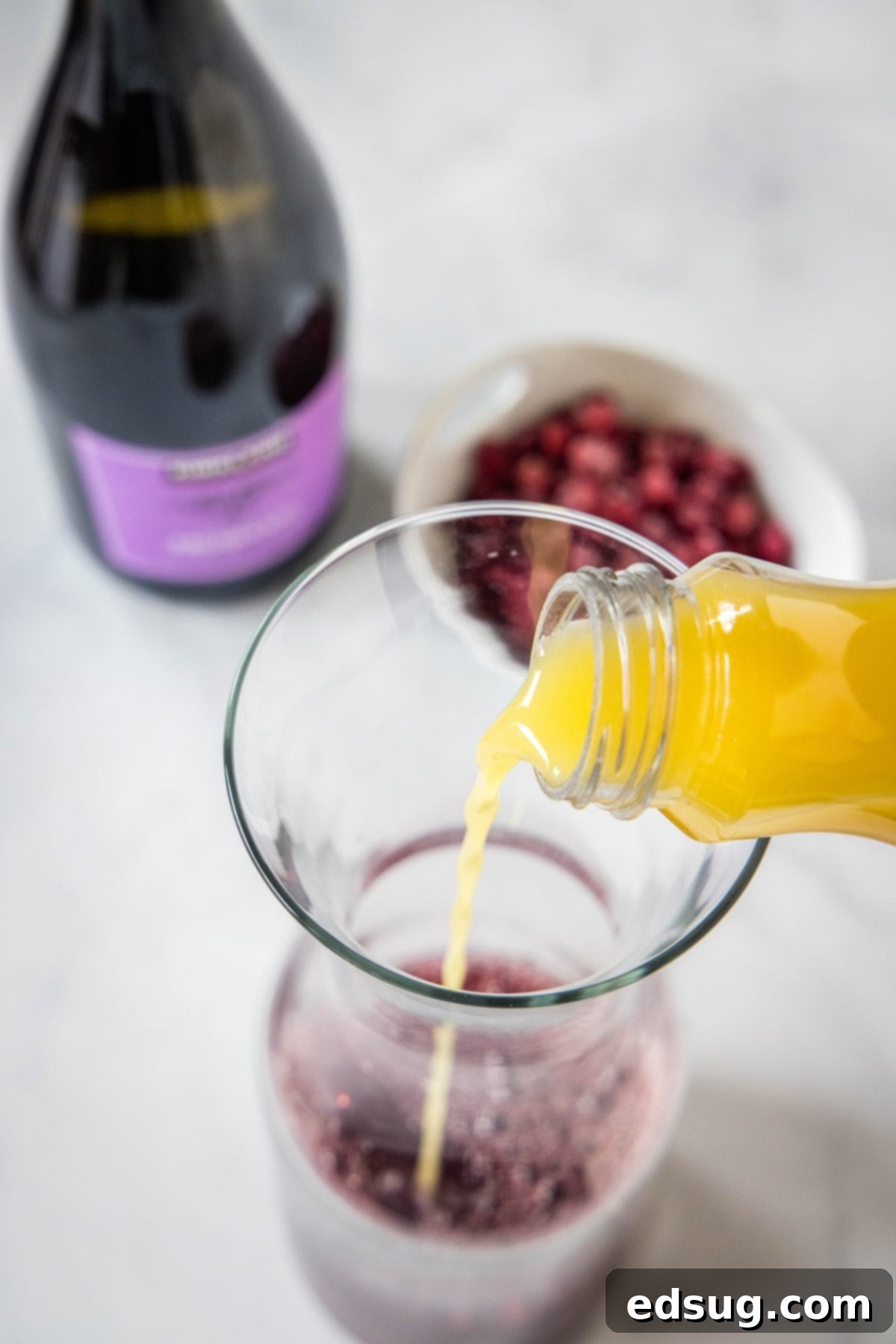 pouring orange juice into a pitcher
