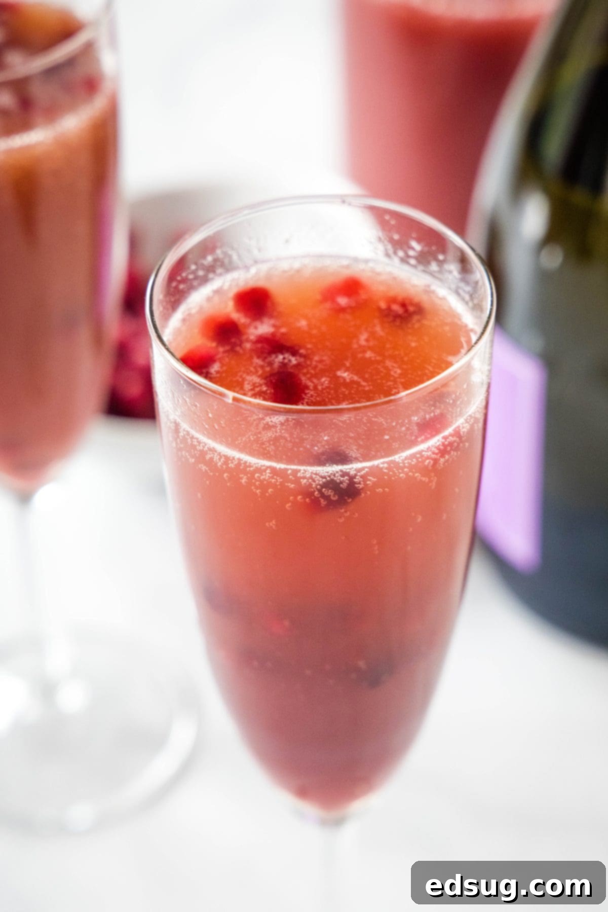 a champagne flute with pomegranate mimosa in it