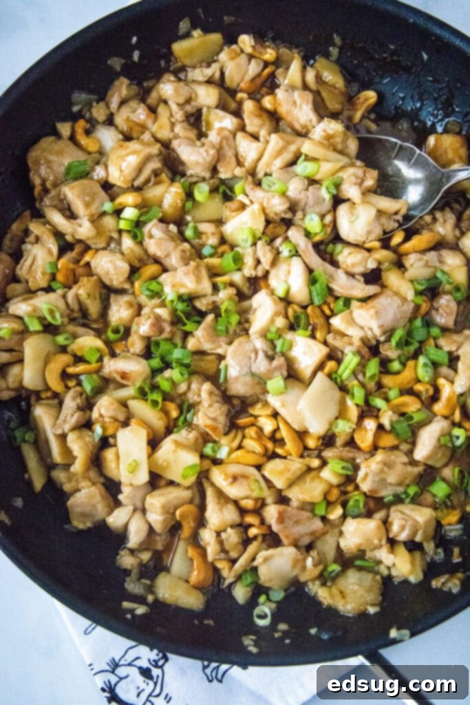 Savory Cashew Chicken Stir-Fry 6 cashew chicken simmering in a large skillet, coated in glossy sauce