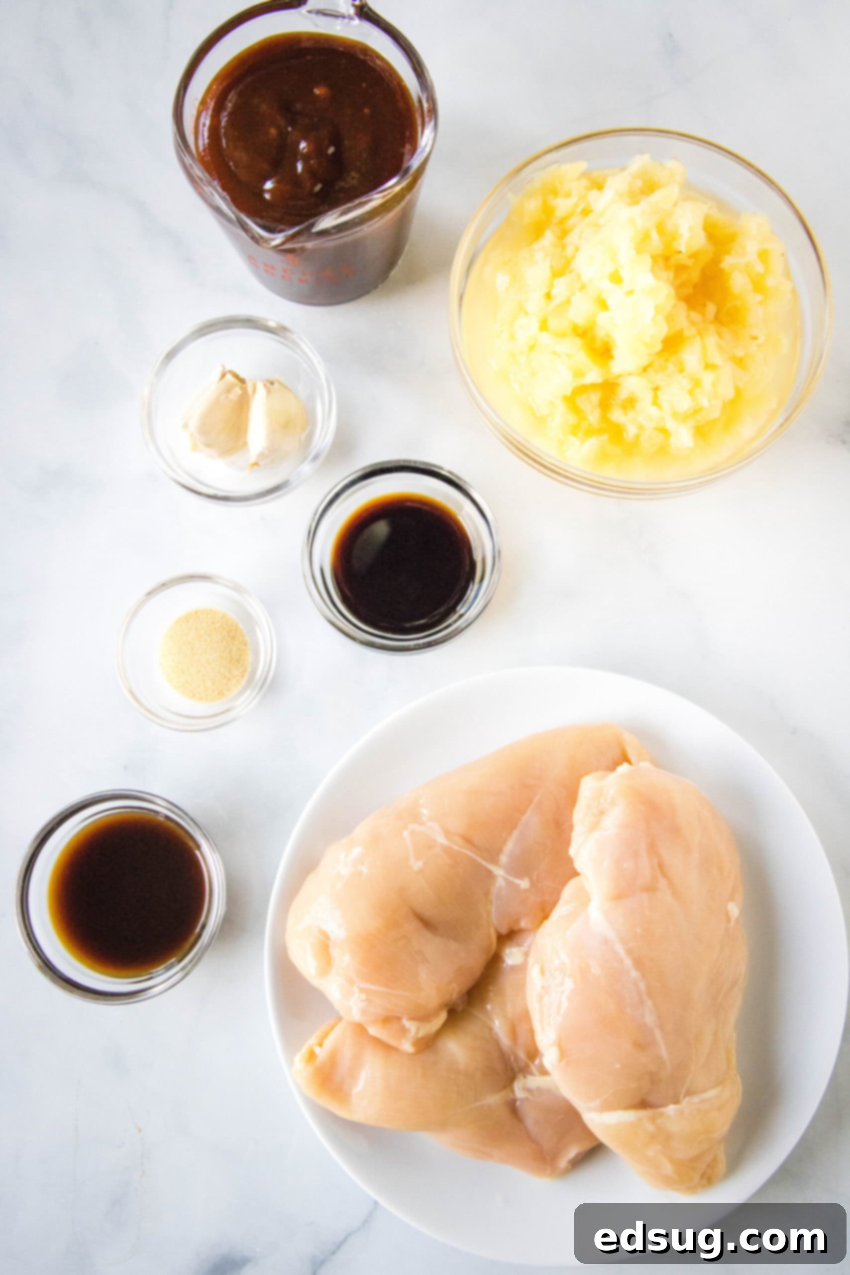 A colorful array of fresh ingredients for slow cooker Hawaiian chicken, including pineapple, barbecue sauce, and chicken breasts, neatly arranged.