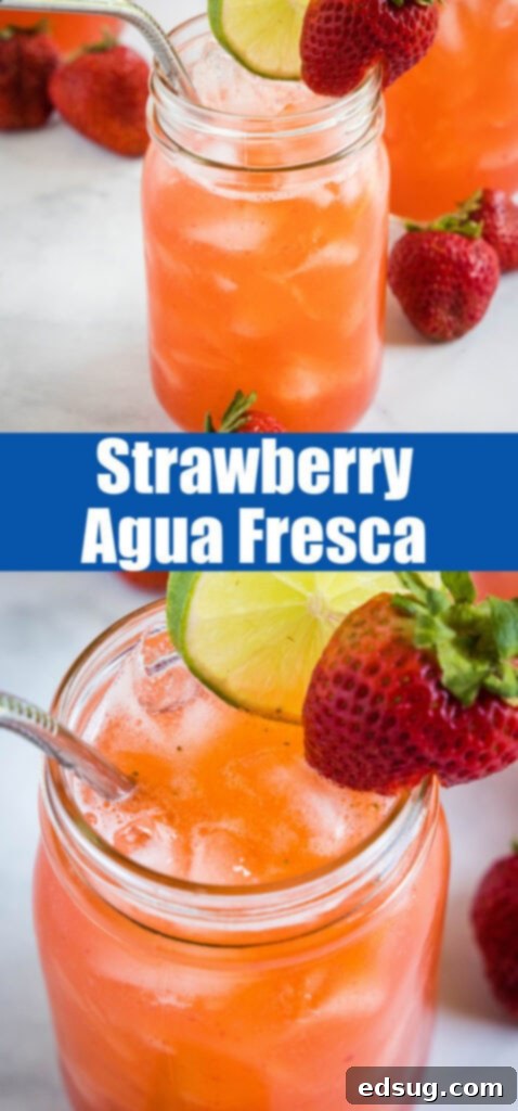 A close-up of a strawberry agua fresca drink, perfectly chilled and garnished with fresh lime, highlighting its vibrant red color and refreshing quality for social media.