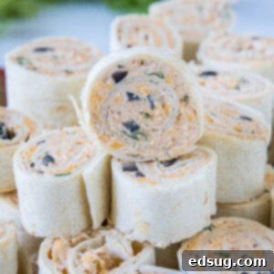 Close up of a stack of taco pinwheels, showcasing the swirled layers of filling and tortilla.