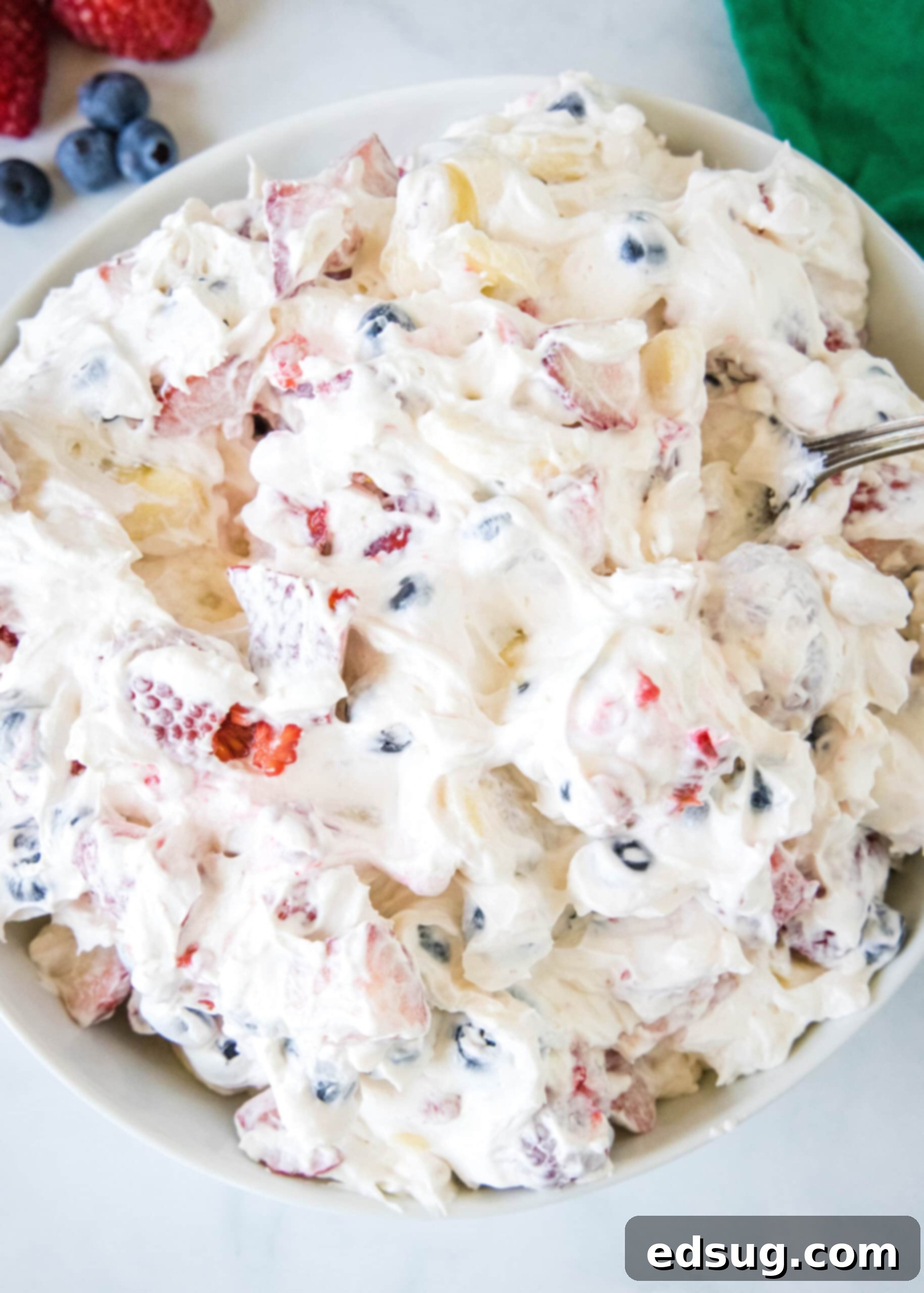 Overhead view of cheesecake fruit salad in a bowl.