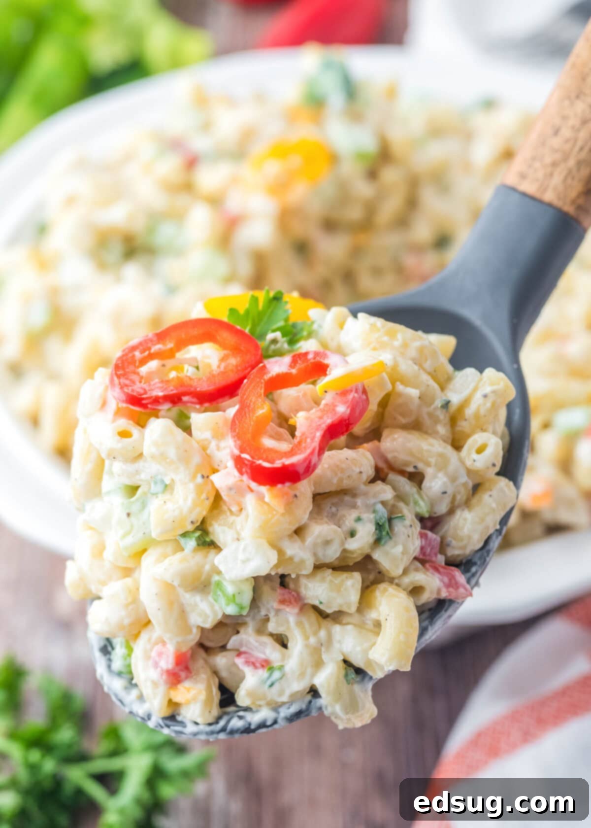 Creamy Macaroni Delight 6 spooning out macaroni salad from a serving bowl