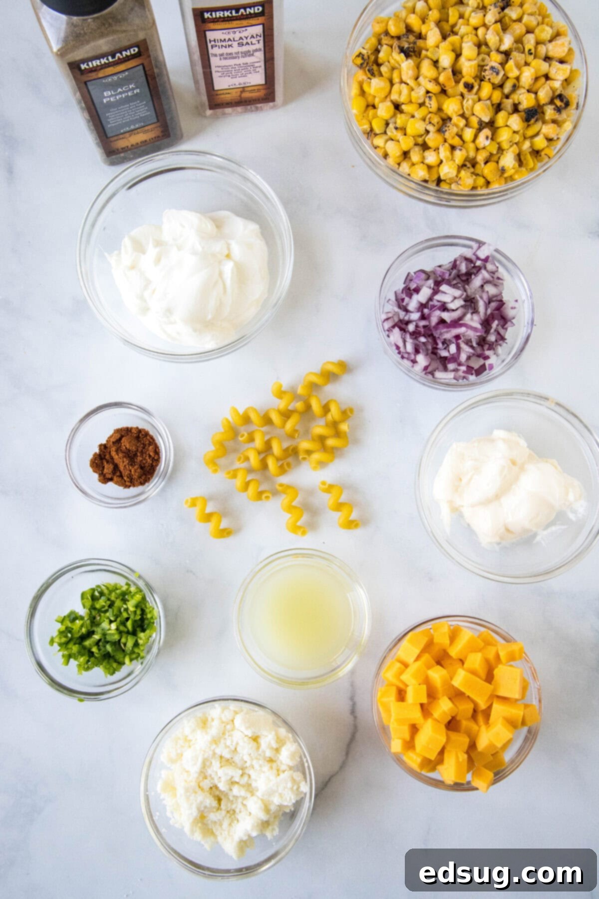A collection of fresh ingredients laid out on a surface, ready for preparing Mexican street corn pasta salad.
