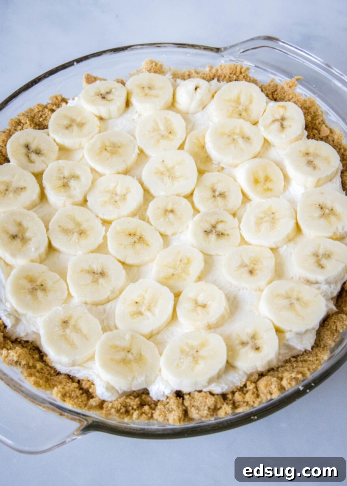 Banana split pie is a cool and creamy no-bake dessert that you can make in 20 minutes. Filled with whipped cream, bananas, and pineapple! Neatly sliced banana rounds meticulously arranged in a single layer over the creamy cream cheese filling within a graham cracker pie crust.