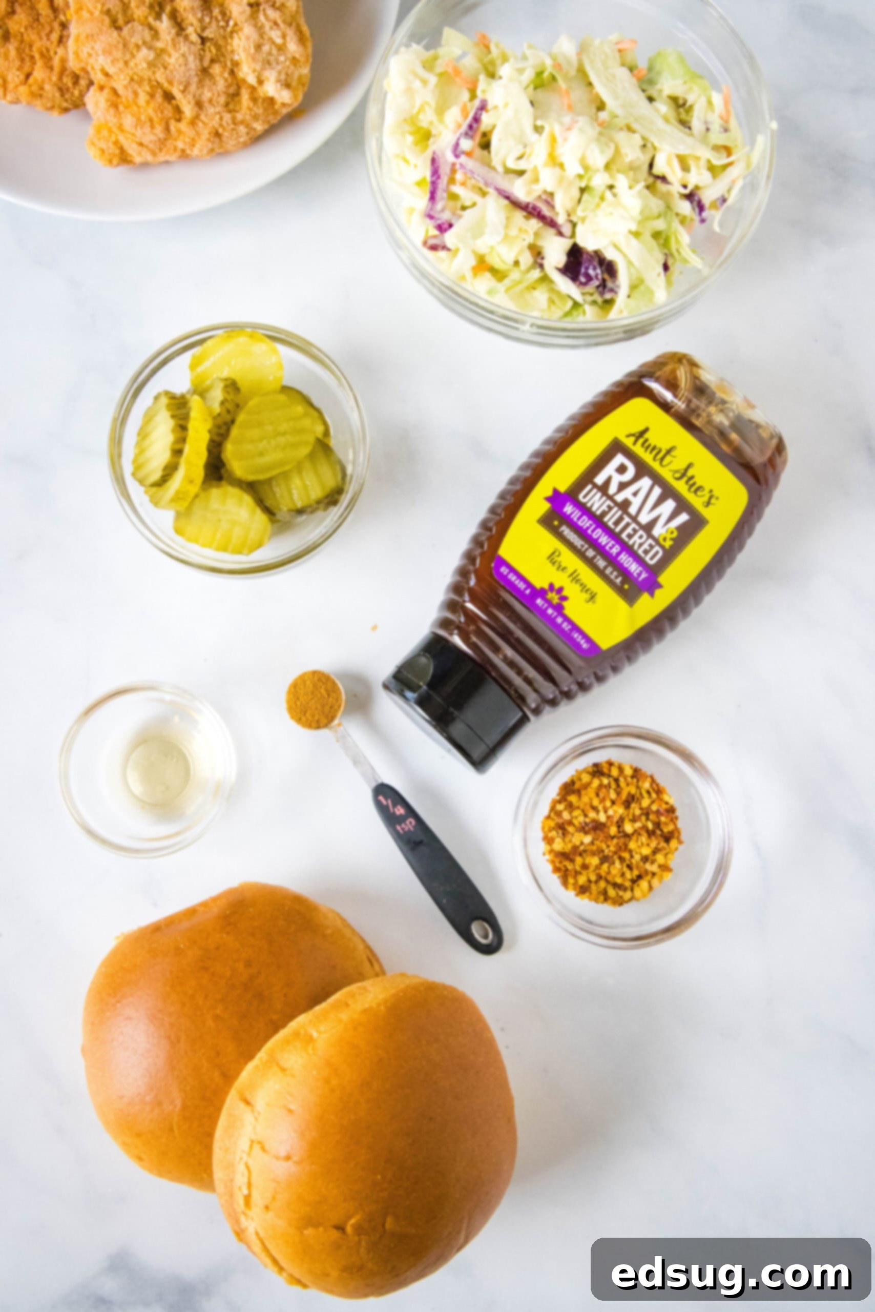 Make a hot honey chicken sandwich with crispy chicken coated in spicy honey, served between fluffy burger buns with cool and crunchy coleslaw! Ingredients for a homemade hot honey chicken sandwich.