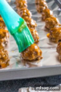 brushing sauce on meatballs