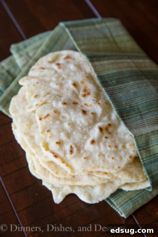 Soft Homemade Flour Tortillas 3 A stack of golden brown homemade flour tortillas, close-up view highlighting their soft texture.