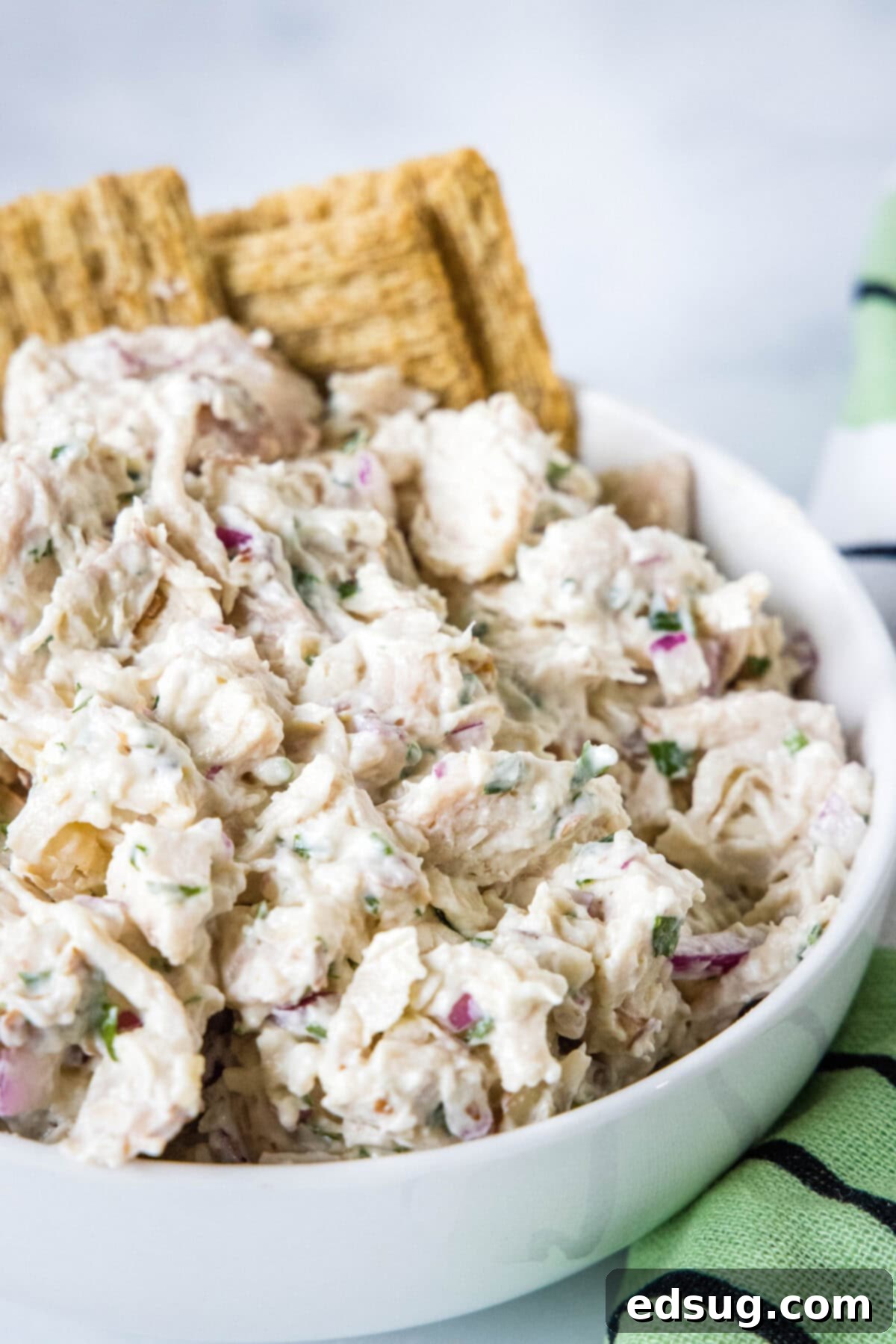 Close-up of creamy Greek yogurt chicken salad in a rustic bowl, showcasing its texture and ready-to-eat appeal.