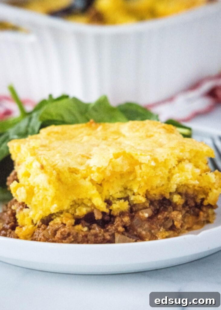Hearty Sloppy Joe Cornbread Pie 6 A slice of Sloppy Joe Cornbread Casserole served on a white plate.