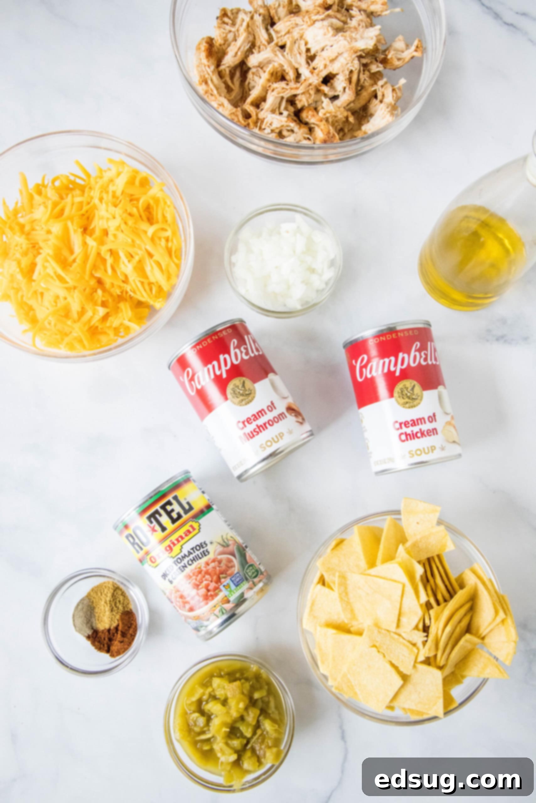 Ingredients for King Ranch chicken casserole laid out on a kitchen counter, including chicken, tortillas, cheese, and canned goods.