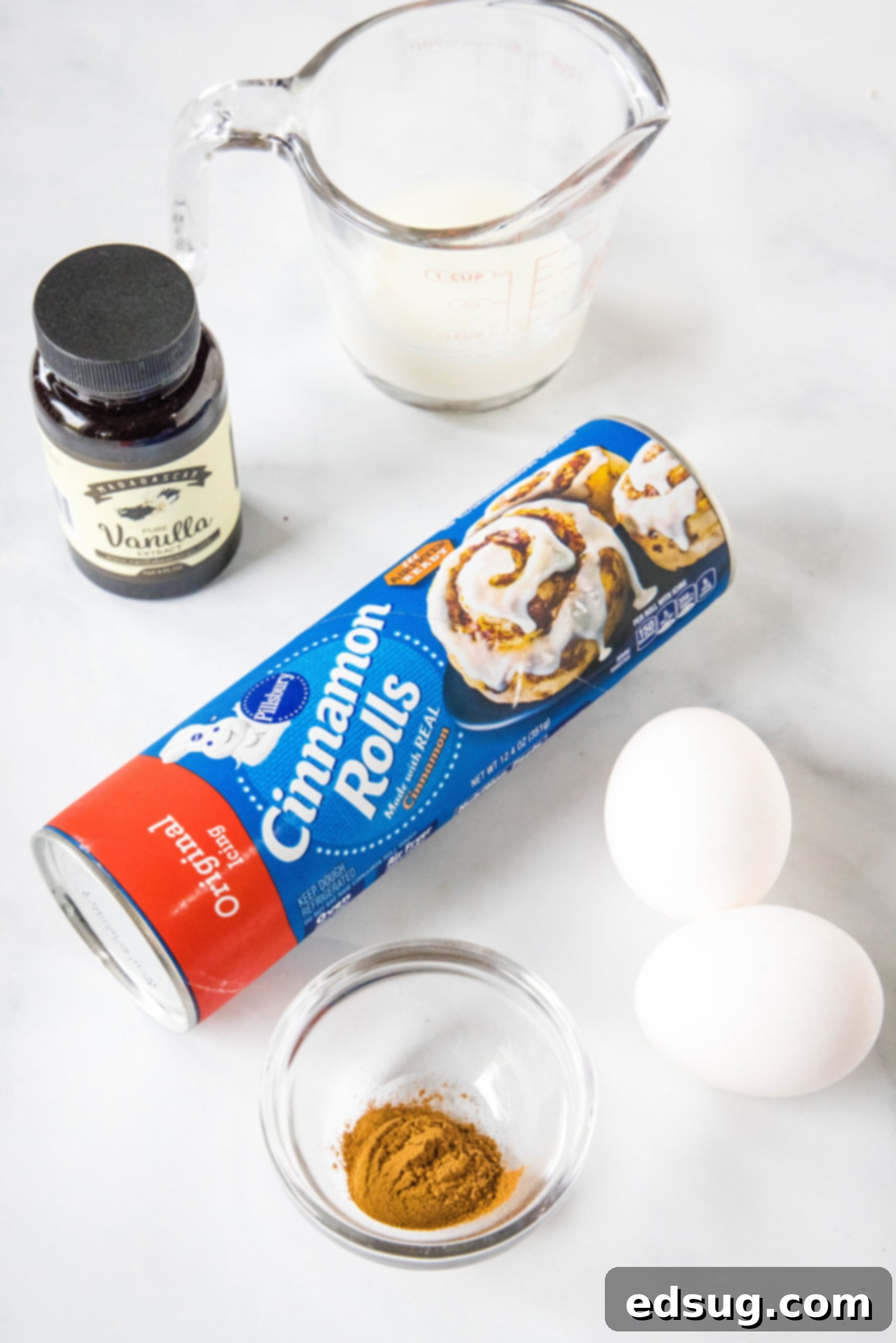 Cinnamon roll casserole is a quick and easy breakfast casserole with flaky layers baked in a rich and creamy custard. Perfect for a crowd! All the simple ingredients laid out for making cinnamon roll casserole: a tube of cinnamon rolls, eggs, milk, vanilla extract, and cinnamon.