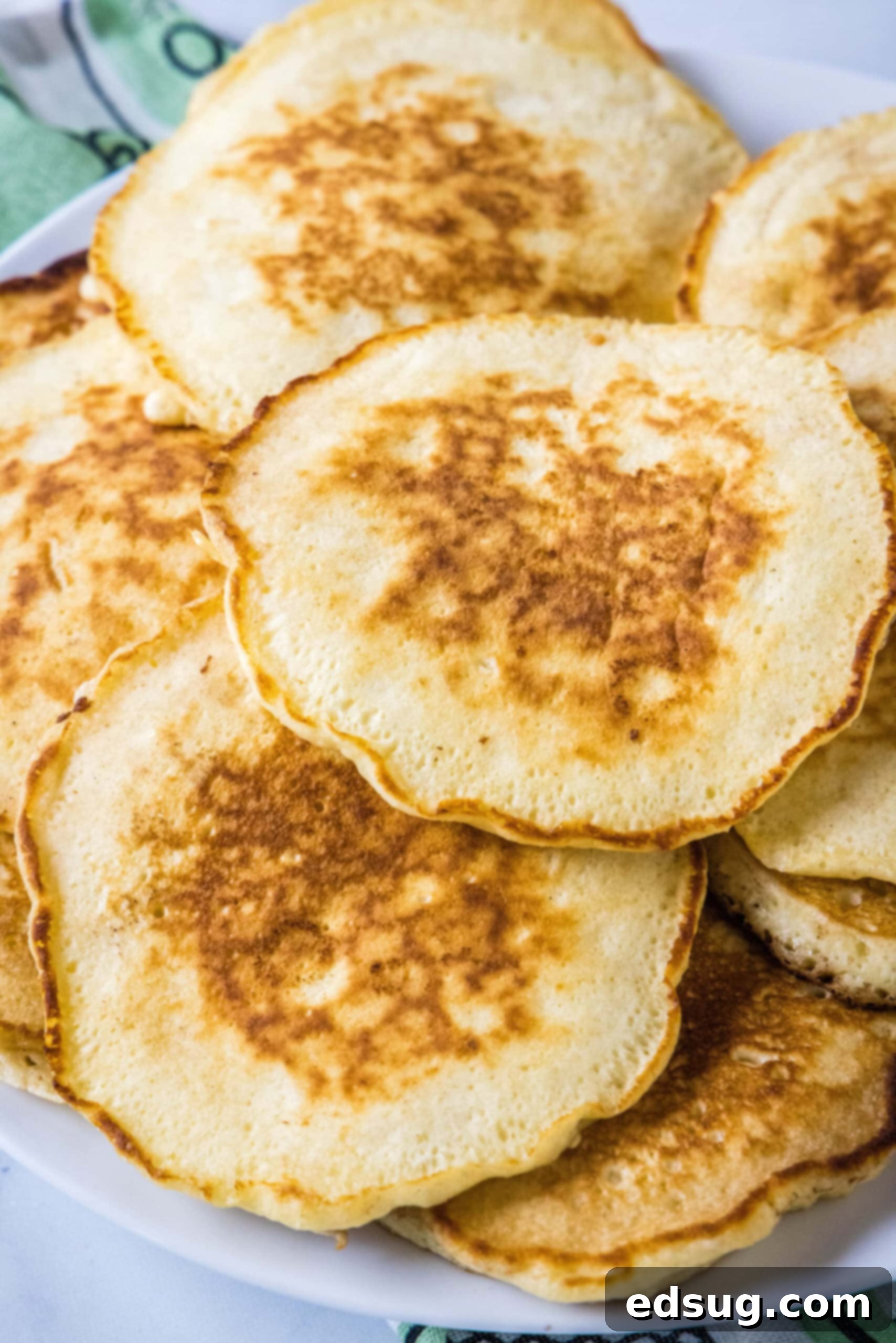 An inviting overhead view of multiple stacks of griddle cakes arranged on a serving platter, highlighting their perfect golden color.