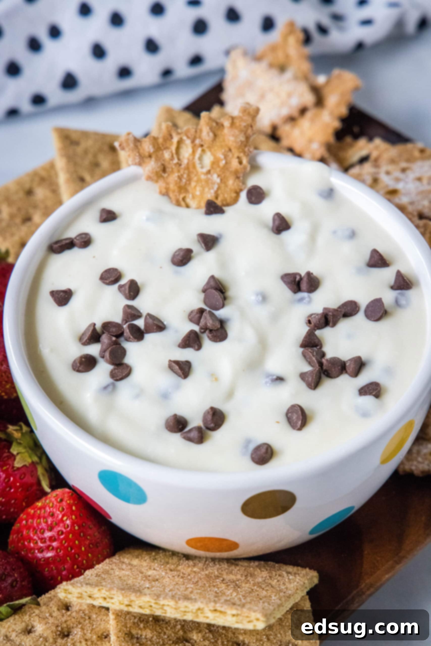 A bowl of creamy cannoli dip surrounded by a platter of golden graham crackers, ready for dipping.