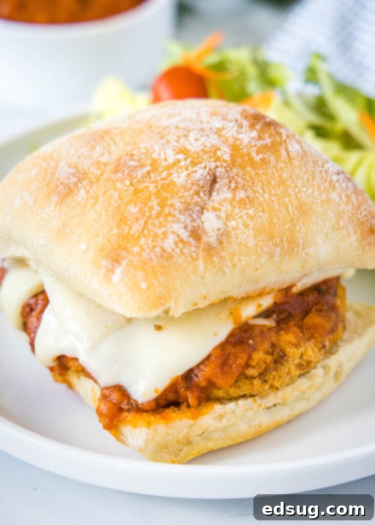 looking down on chicken parmesan sandwich on white plate