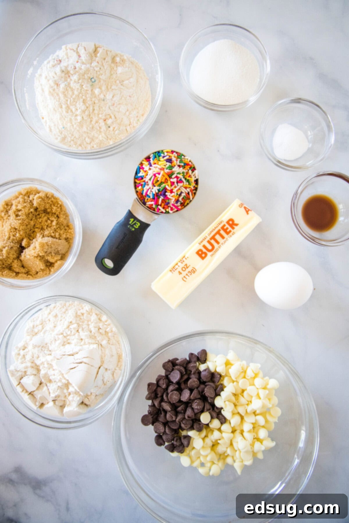 Dreamy Cake Batter Cookies 3 all ingredients for cake batter cookies laid out on a table, including flour, cake mix, sugars, butter, eggs, vanilla, and chocolate chips