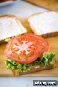 Ultimate Turkey Club Sandwich 9 lettuce and tomato on a slice of bread