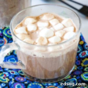 Hot chocolate in a clear mug topped with mini marshmallows.