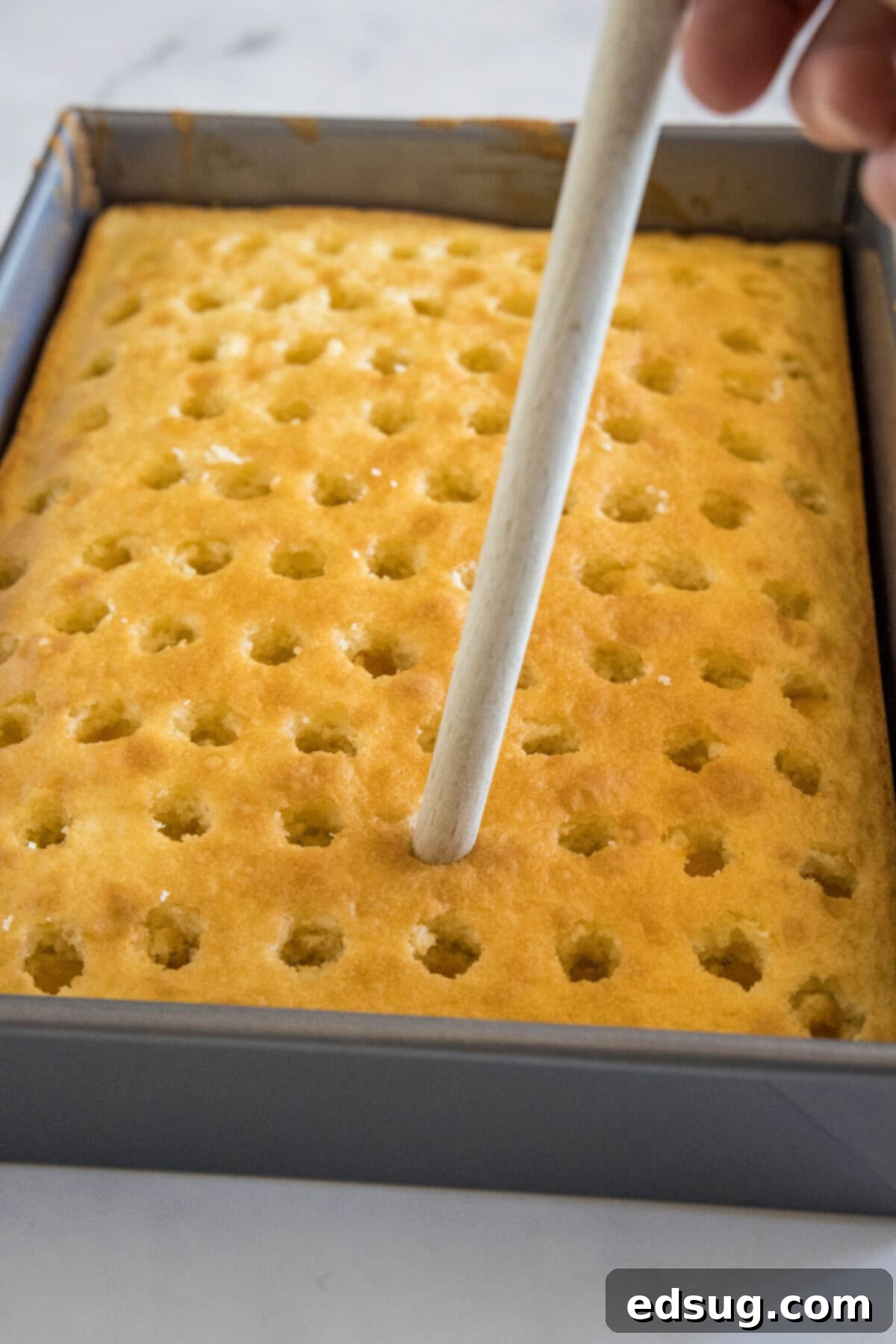 Holiday Hidden Gem 4 using wooden spoon to poke holes in hake