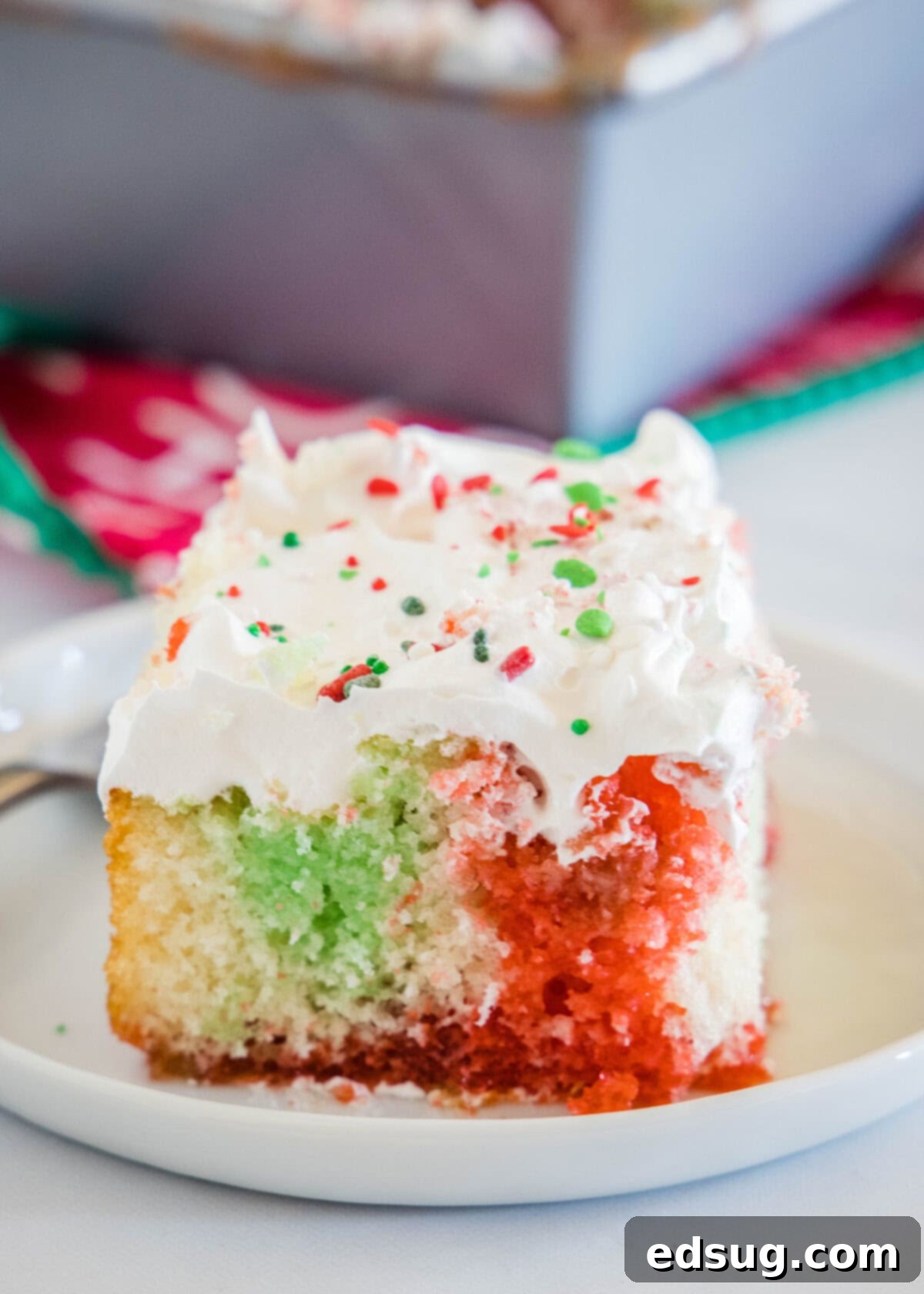 Holiday Hidden Gem 7 red and green poke cake on a white plate