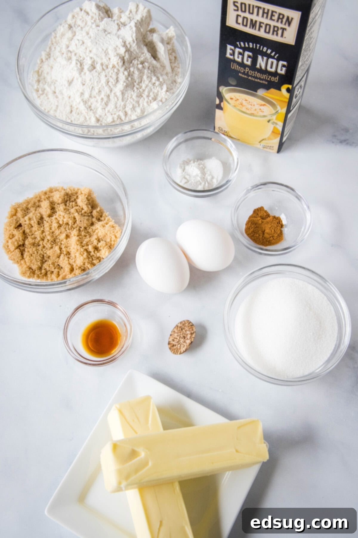 Festive Eggnog Cookies 3 ingredients laid out for eggnog sugar cookies, including butter, sugar, flour, eggnog, and spices.