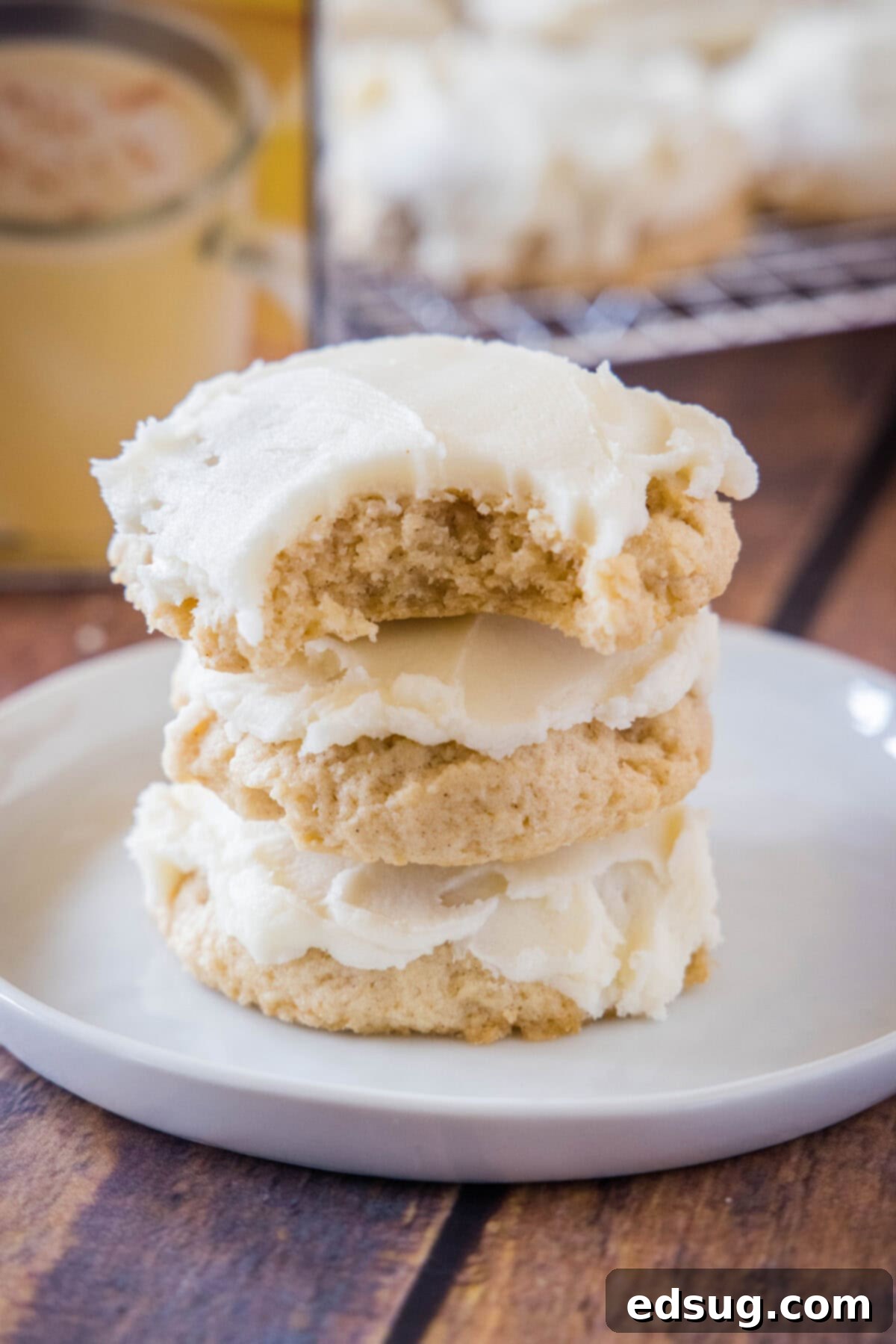 Festive Eggnog Cookies 6 eggnog cookies stacked with a bite taken out of one of them, revealing the soft interior.