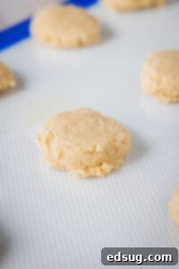 Festive Eggnog Cookies 9 flattened ball of dough on a baking sheet, ready to be baked.