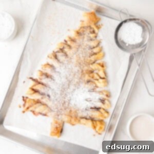 cropped close up puff pastry christmas tree dusted with powdered sugar on a baking sheet