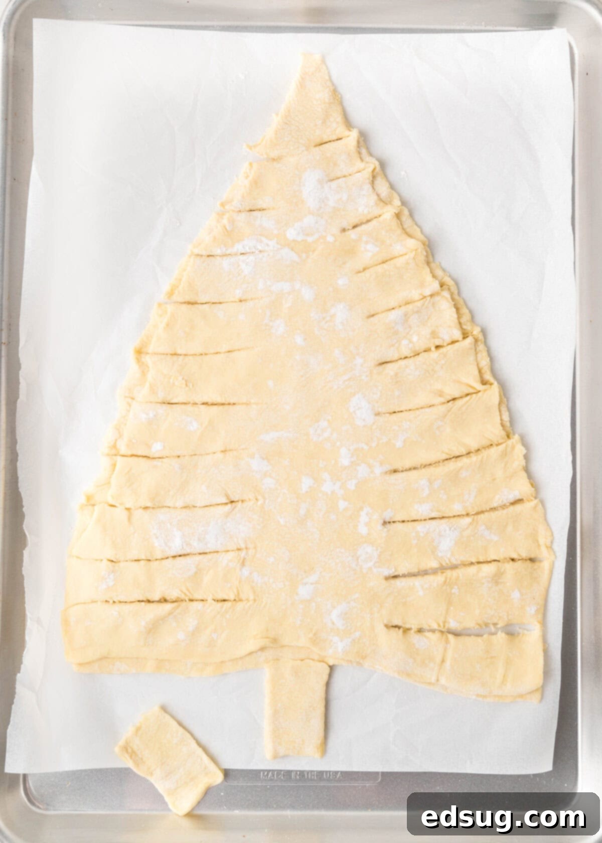 Holiday Swirl Pastry Tree 5 The process of cutting individual branches into the puff pastry tree shape, leaving a central spine for twisting.